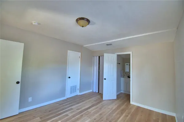a view of an empty room with wooden floor