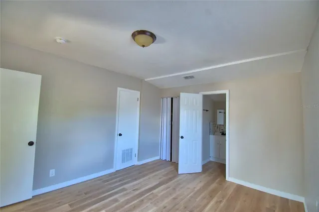 a view of an empty room with wooden floor