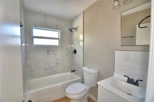a white toilet sitting next to a bath tub