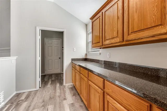 a kitchen with granite countertop wooden cabinets a sink and dishwasher