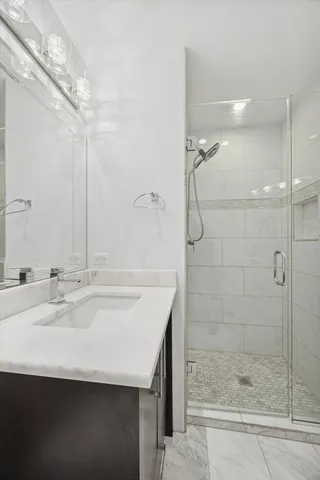 a bathroom with a shower sink and mirror
