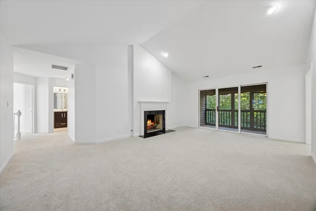 a view of an empty room with a fireplace and a window