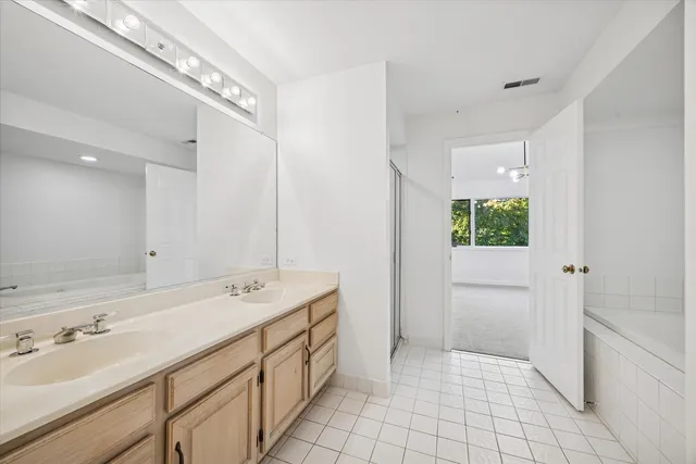 a spacious bathroom with a shower sink and mirror