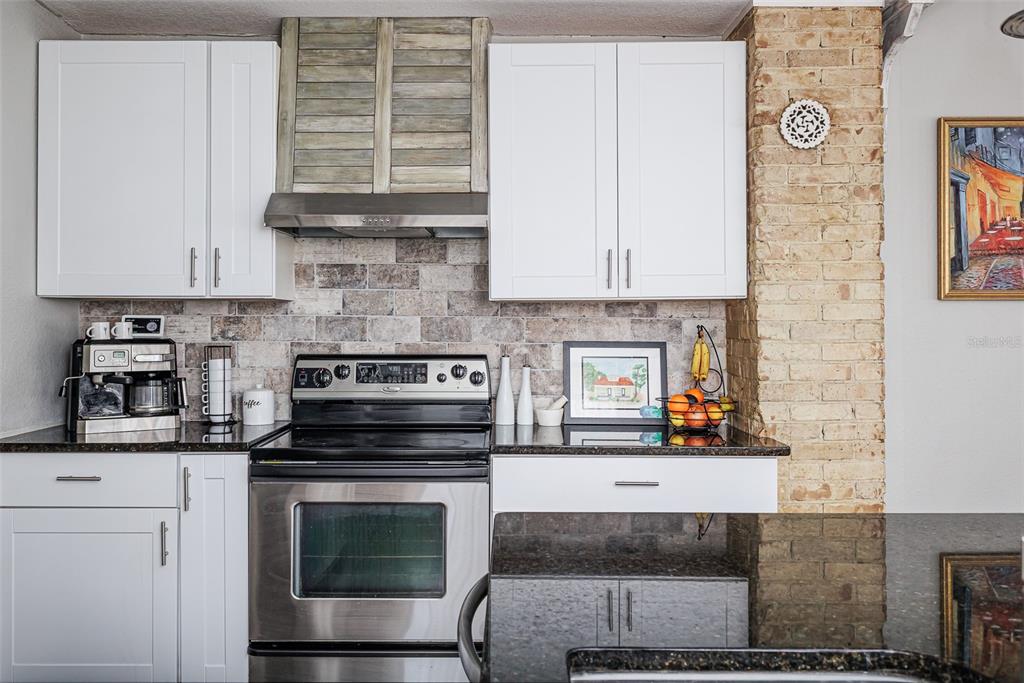 749 South Rushing Avenue Lakeland, FL 33801 - Photo 11 of 45 a kitchen with granite countertop a stove and a white cabinets