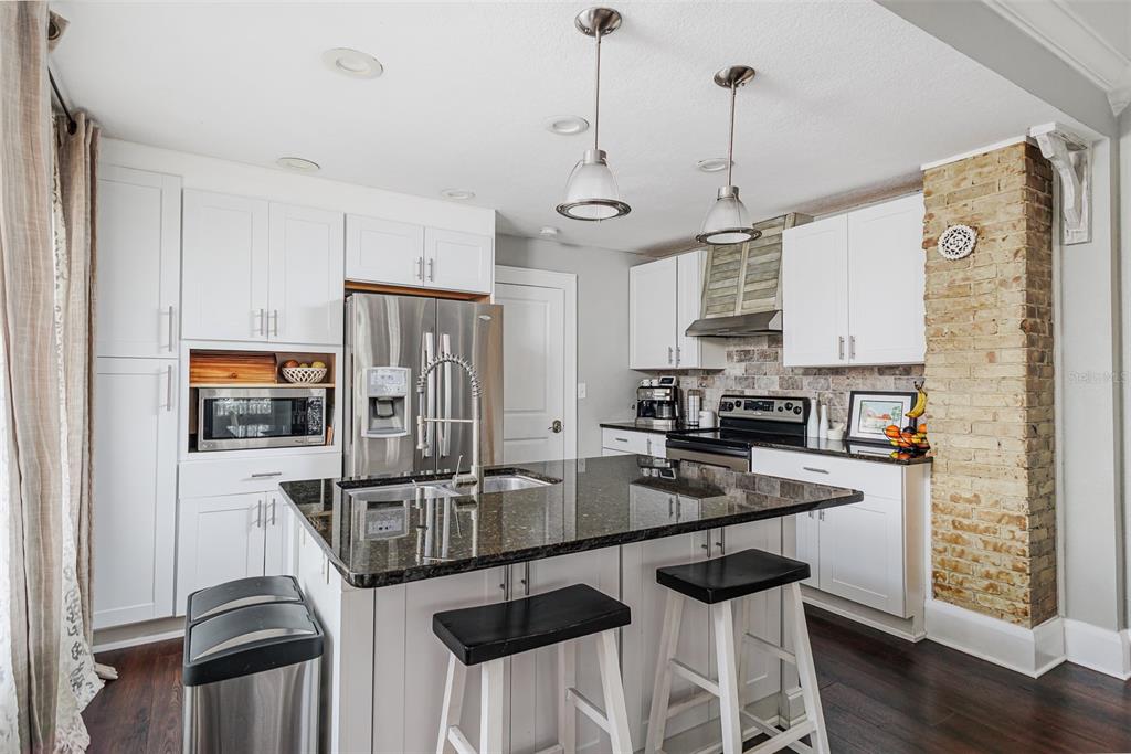 749 South Rushing Avenue Lakeland, FL 33801 - Photo 12 of 45 a kitchen with stainless steel appliances granite countertop a stove a refrigerator a oven a sink with a dining table and chairs