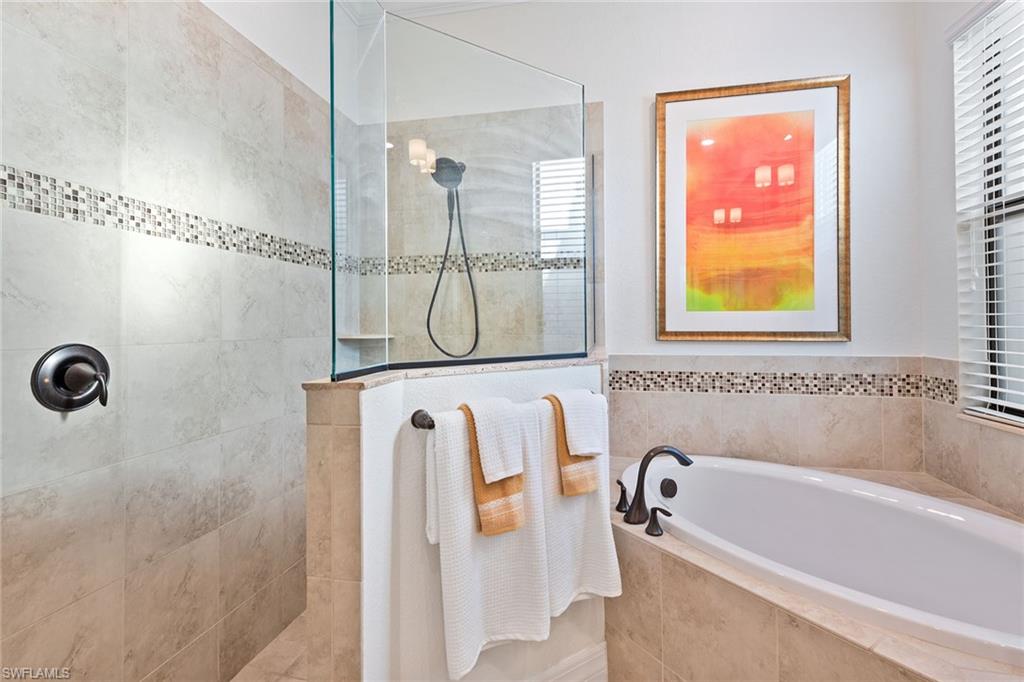 2806 Aviamar Circle Naples, FL 34114 - Photo 12 of 50 a bathroom with a tub a mirror and a shower
