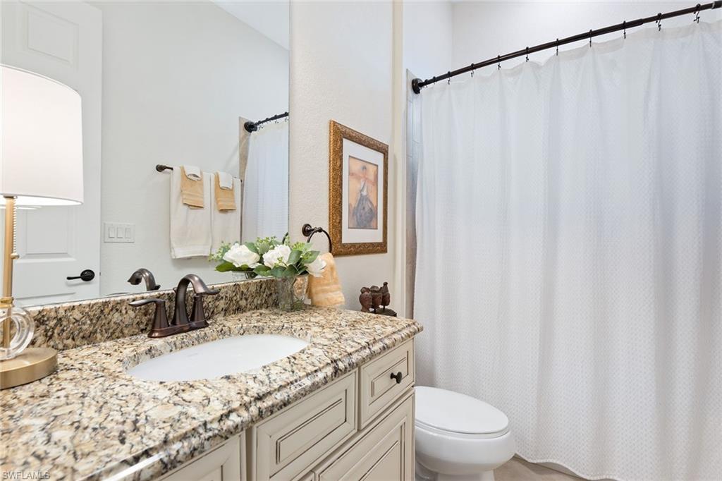 2806 Aviamar Circle Naples, FL 34114 - Photo 14 of 50 a bathroom with a granite countertop sink and a mirror