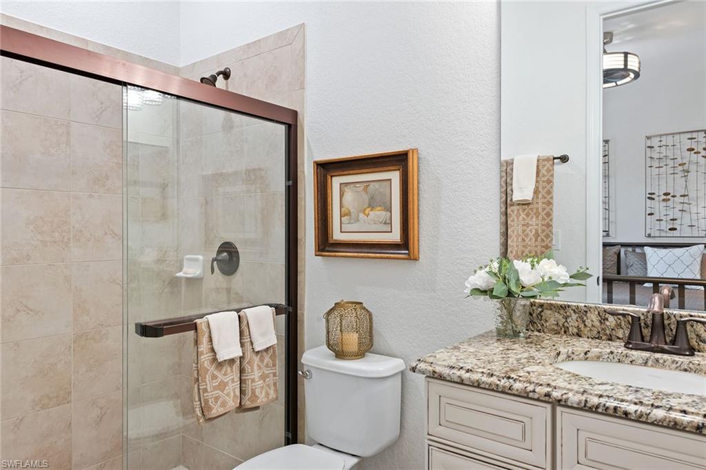2806 Aviamar Circle Naples, FL 34114 - Photo 16 of 50 a bathroom with a granite countertop sink a toilet and shower