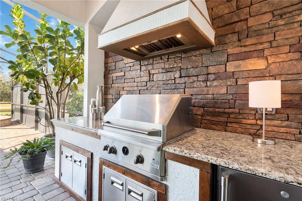 2806 Aviamar Circle Naples, FL 34114 - Photo 20 of 50 a open kitchen with stainless steel appliances granite countertop a stove a sink and a microwave