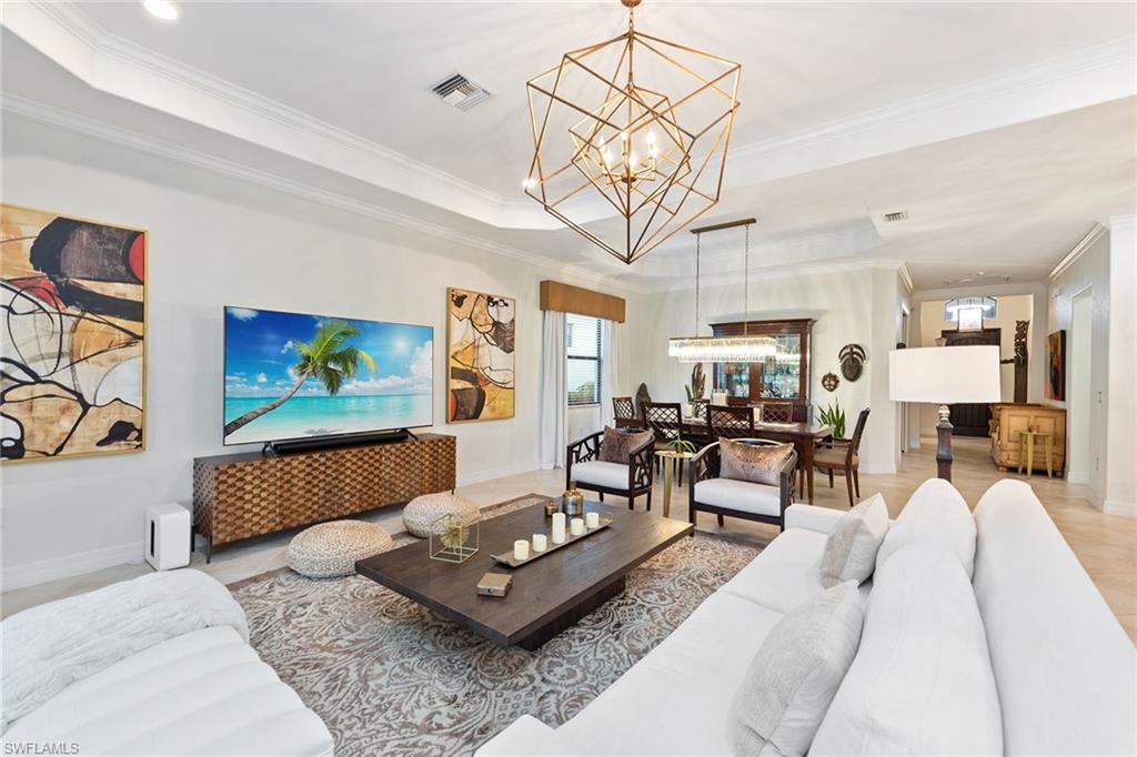 2806 Aviamar Circle Naples, FL 34114 - Photo 2 of 50 a living room with furniture a chandelier and a flat screen tv