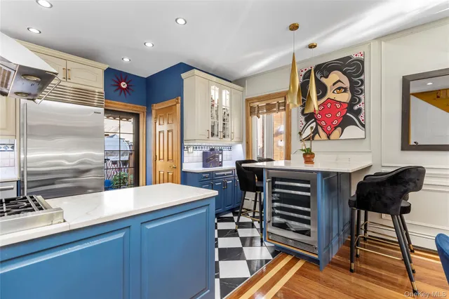 a kitchen with stainless steel appliances kitchen island granite countertop a sink and a refrigerator