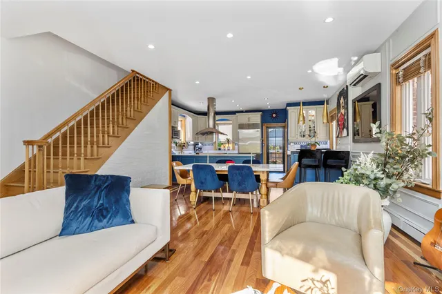 a living room with furniture and a dining table with wooden floor