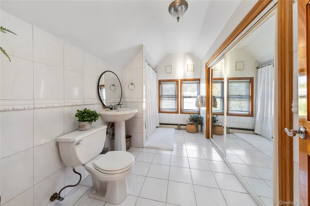 a bathroom with a toilet a sink and a mirror