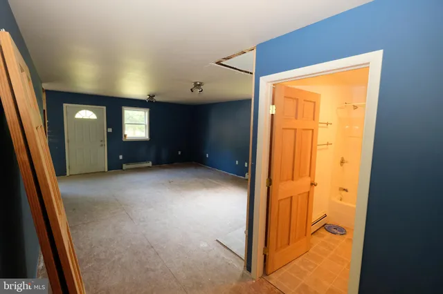 an empty room with chandelier fan