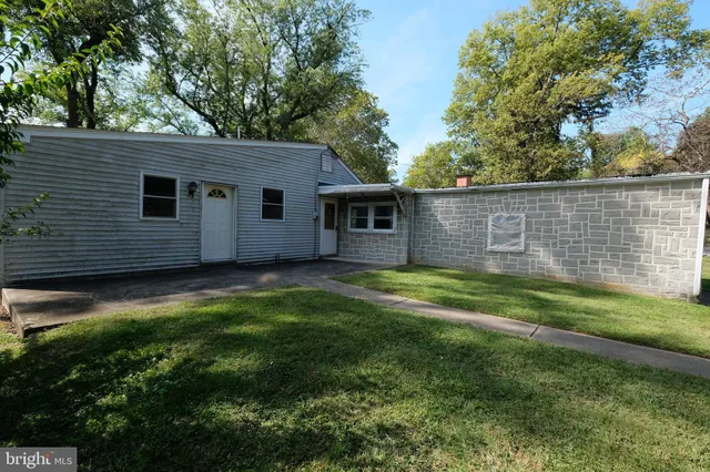 a view of house with backyard and outdoor seating