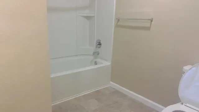 a white bath tub sitting next to a toilet