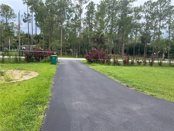 a front view of a house with a yard and a fountain