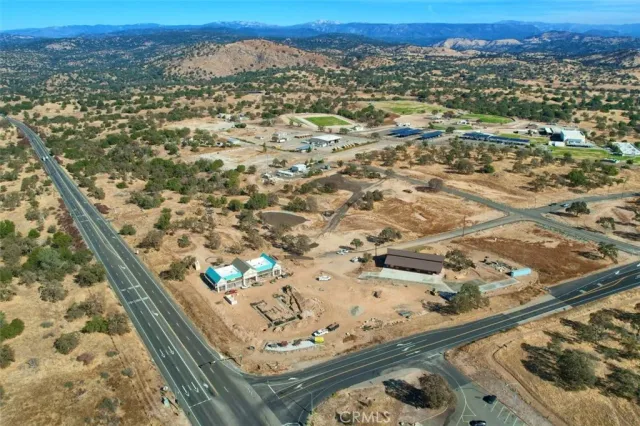 a view of dirt yard with mountain and trees around