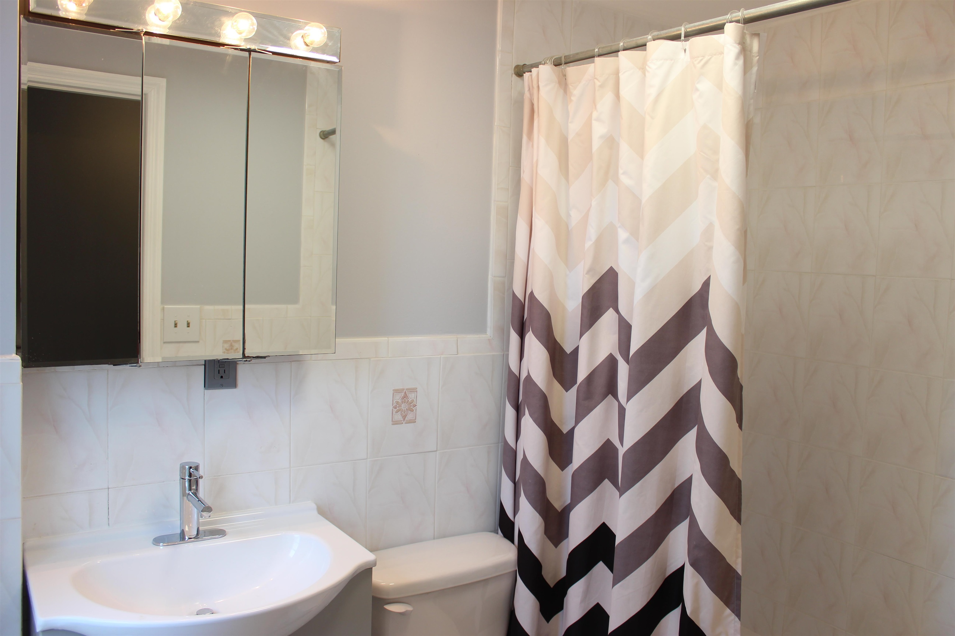 182 Christopher Columbus Drive, Unit 2 Jersey City, NJ 07302 - Photo 2 of 12 a bathroom with a sink and mirror with toilet