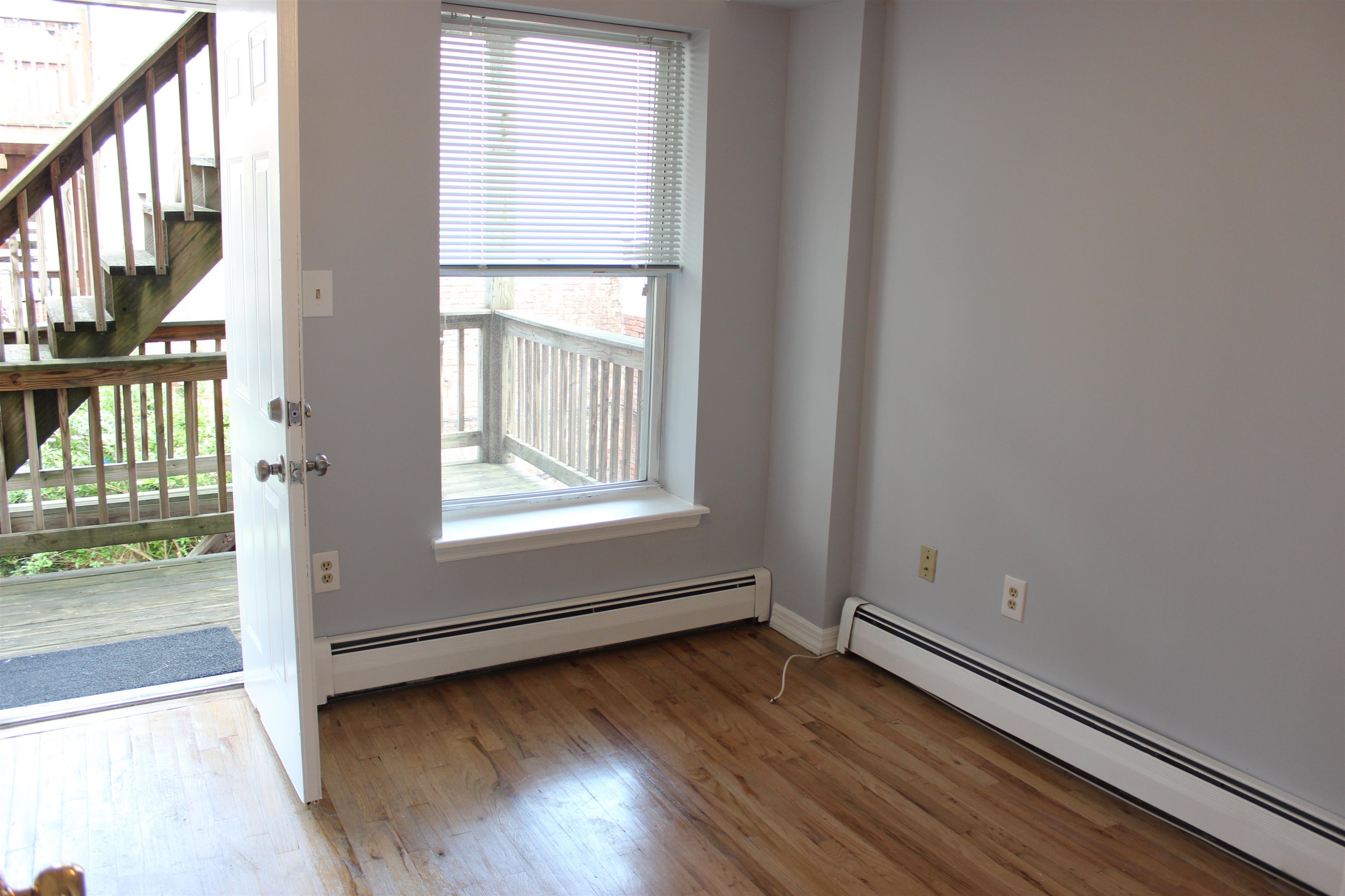 182 Christopher Columbus Drive, Unit 2 Jersey City, NJ 07302 - Photo 4 of 12 an empty room with wooden floor and windows