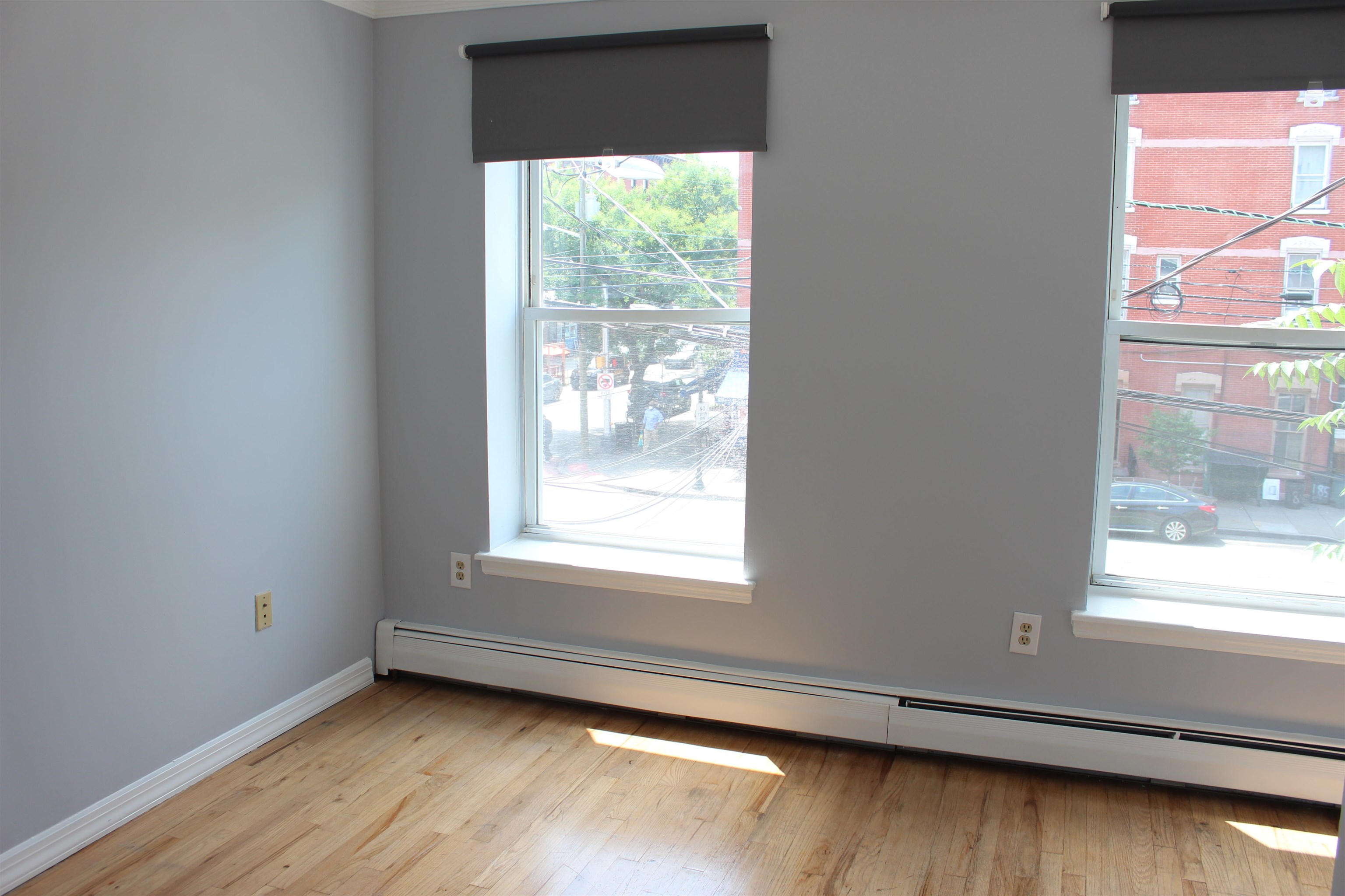 182 Christopher Columbus Drive, Unit 2 Jersey City, NJ 07302 - Photo 7 of 12 a view of an empty room with wooden floor and a window