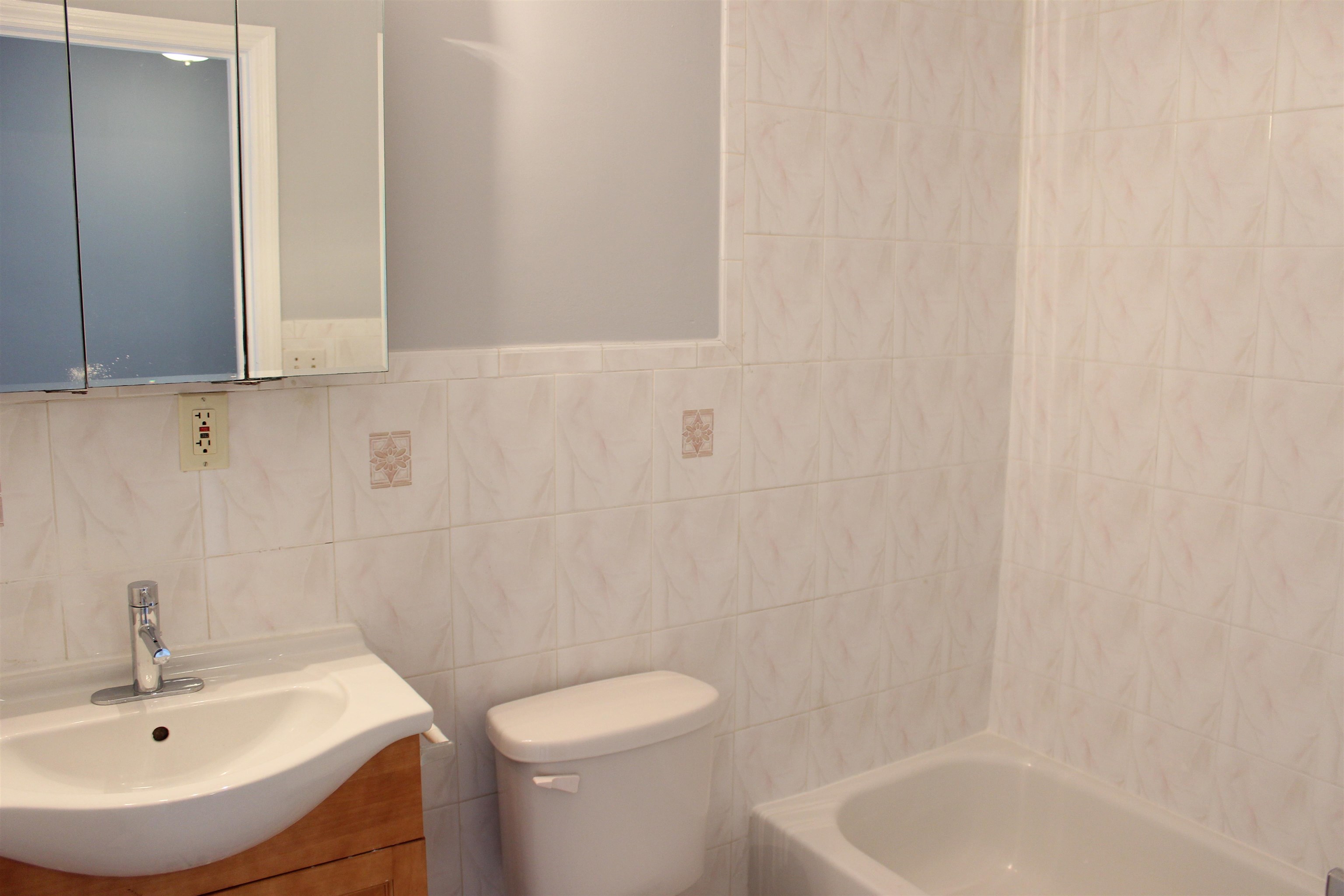 182 Christopher Columbus Drive, Unit 2 Jersey City, NJ 07302 - Photo 9 of 12 a bathroom with a sink a toilet and shower