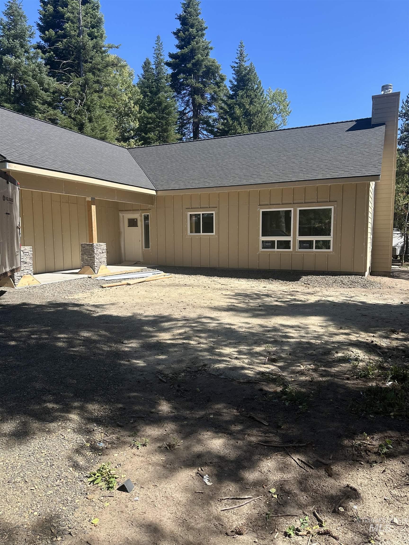 1760 Warren Wagon Road McCall, ID 83638 - Photo 1 of 5 Single-story residence featuring a covered front entry with stone-wrapped columns, vertical panel siding, and multiple windows