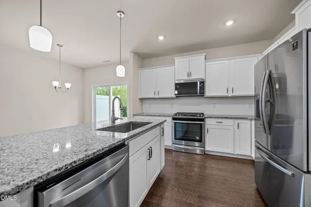 a kitchen with a sink stainless steel appliances and white cabinets