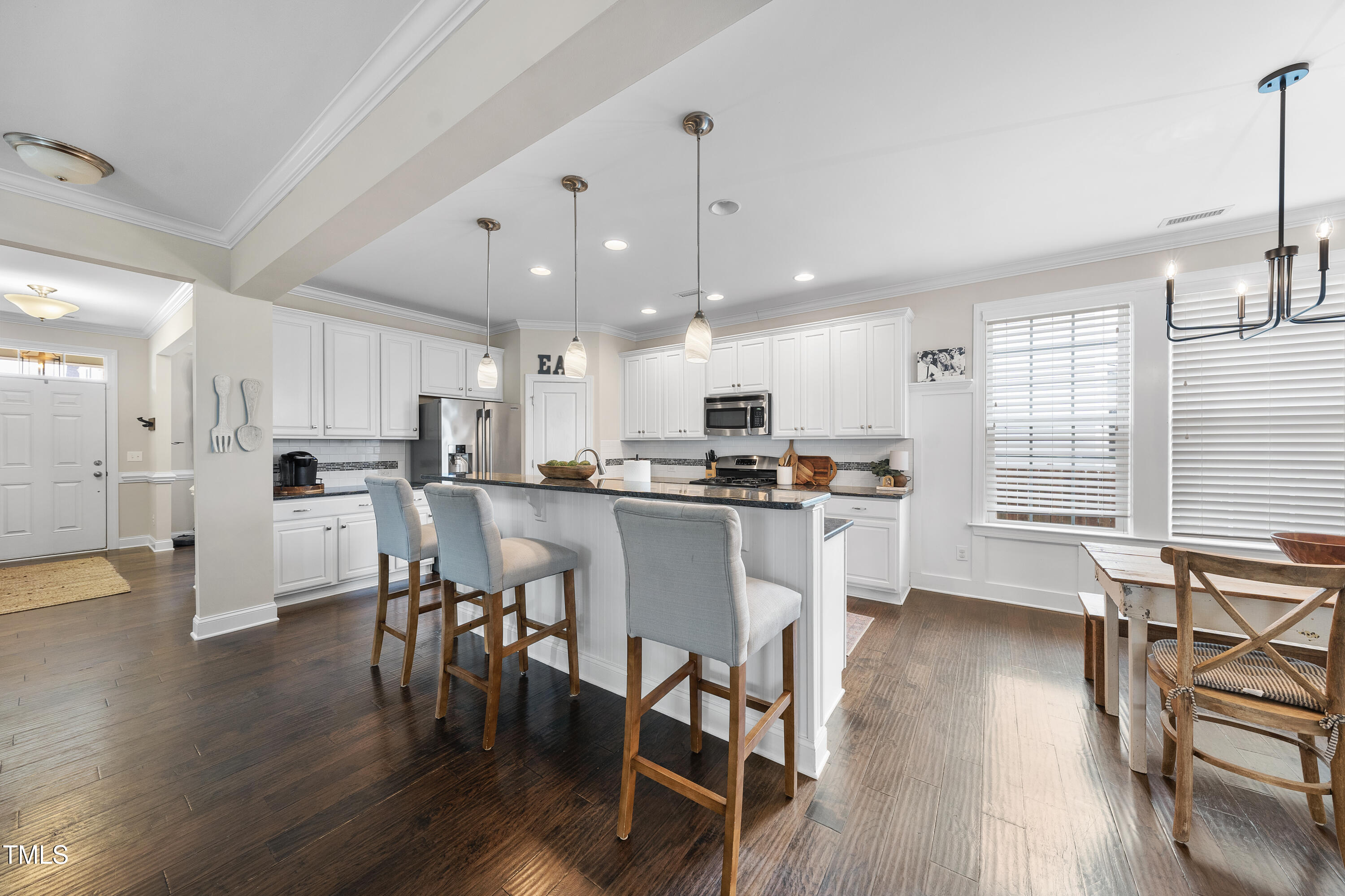 714 Chapanoke Road Raleigh, NC 27603 - Photo 11 of 45 a kitchen with a dining table chairs wooden floor cabinets and stainless steel appliances