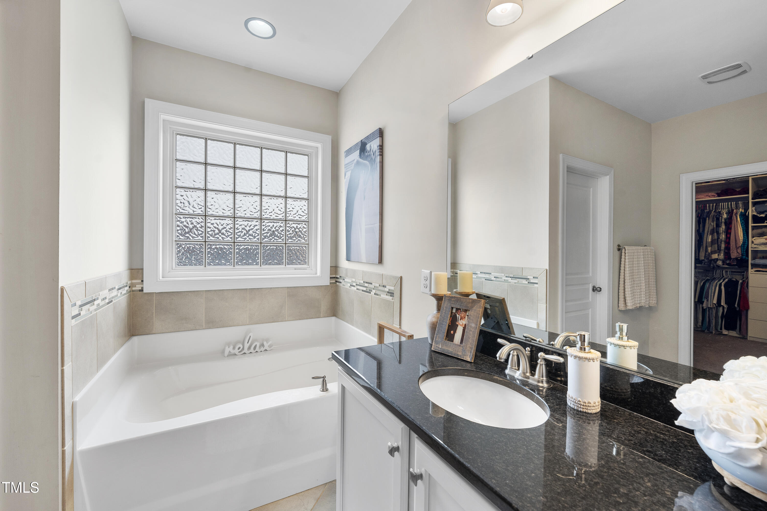 714 Chapanoke Road Raleigh, NC 27603 - Photo 30 of 45 a bathroom with a granite countertop sink and a bathtub