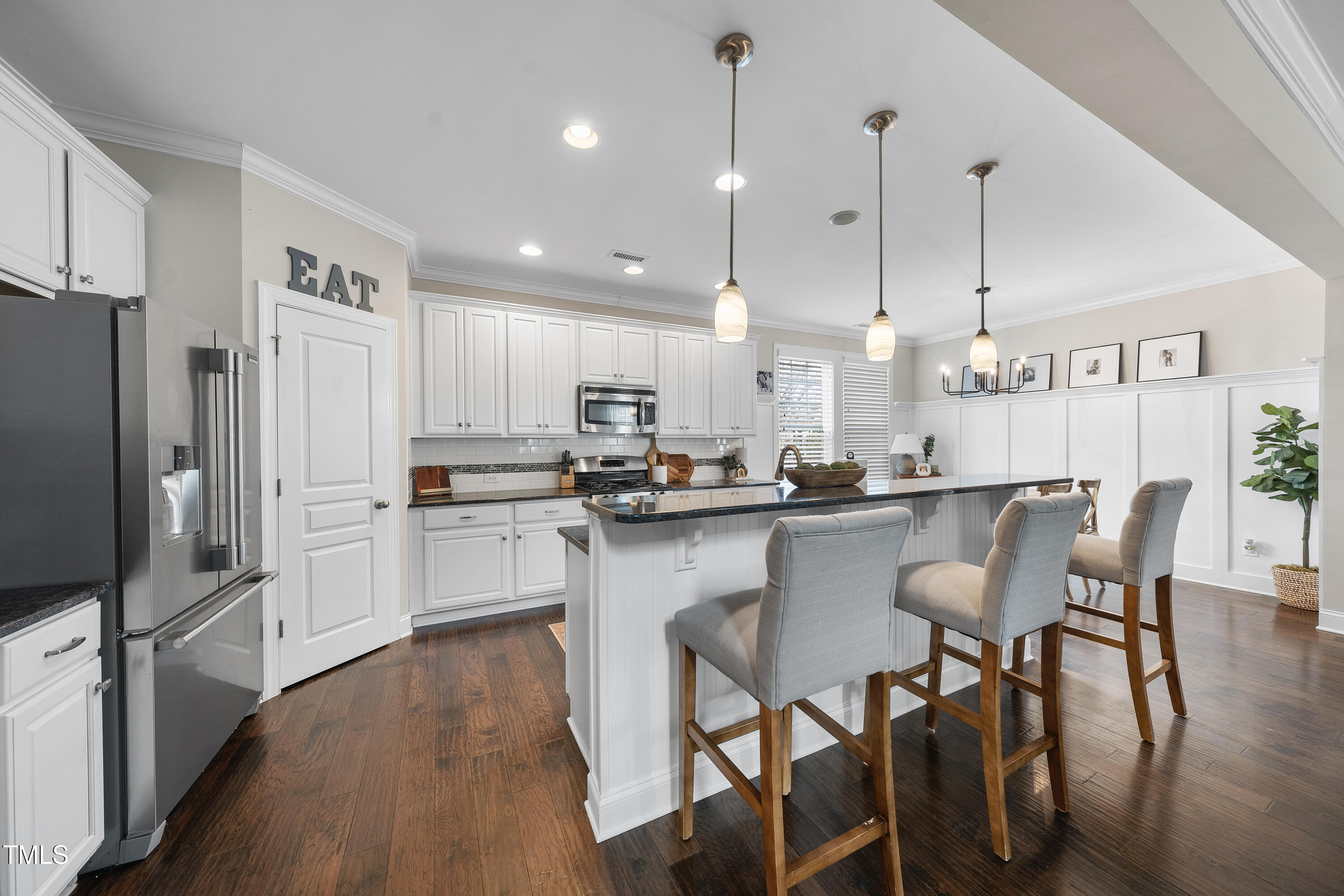 714 Chapanoke Road Raleigh, NC 27603 - Photo 9 of 45 a kitchen with kitchen island granite countertop a table chairs microwave and cabinets