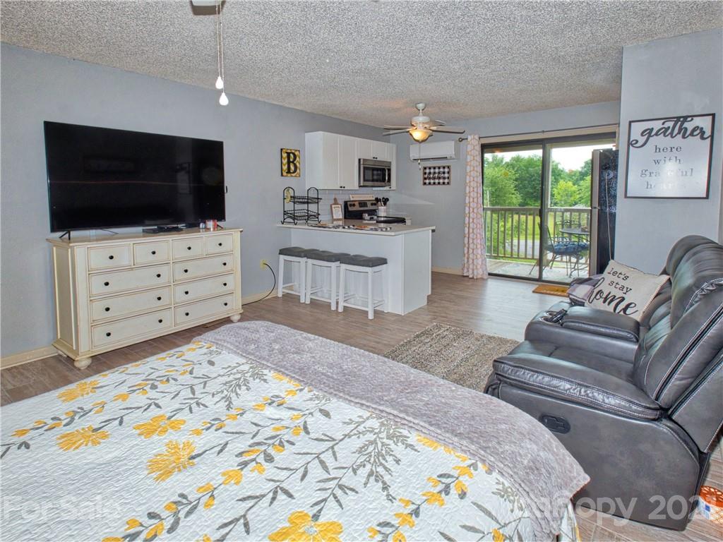 160 Whitney Boulevard, Unit 65 Lake Lure, NC 28746 - Photo 5 of 21 a living room with furniture and a flat screen tv