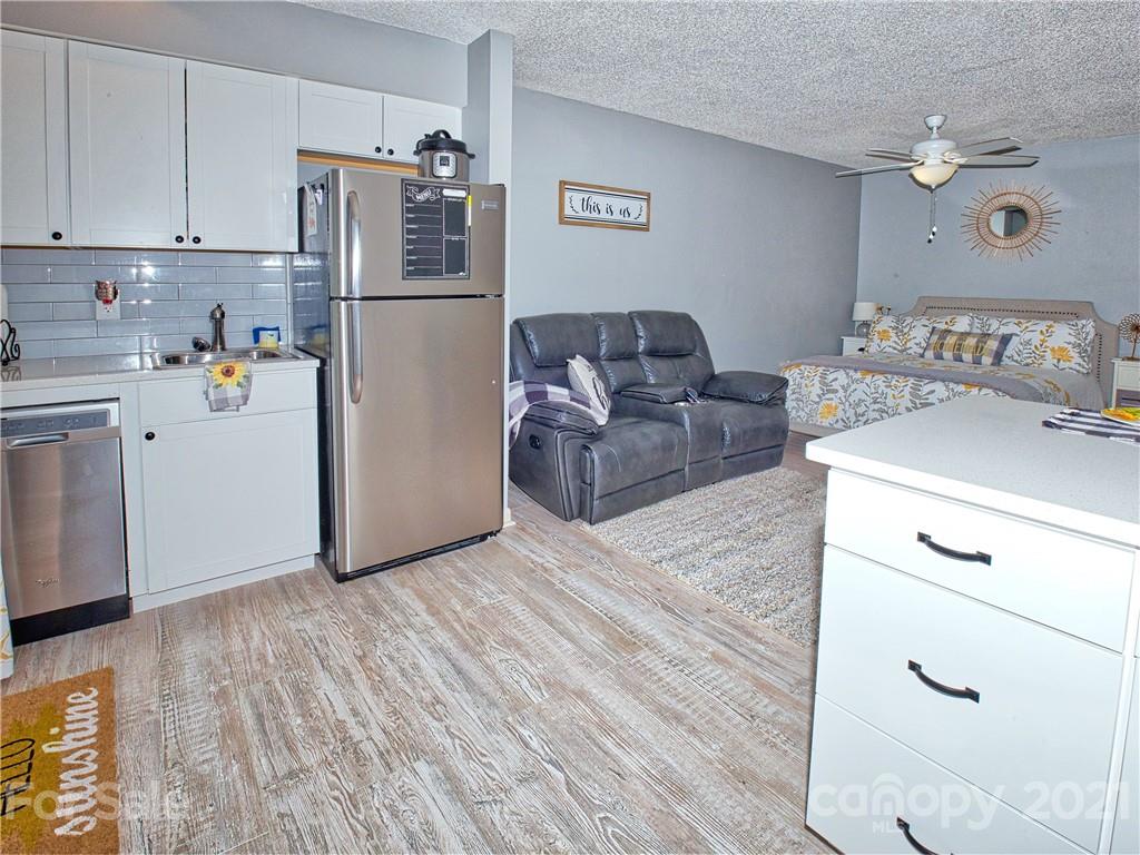 160 Whitney Boulevard, Unit 65 Lake Lure, NC 28746 - Photo 8 of 21 a kitchen with stainless steel appliances a refrigerator sink and cabinets