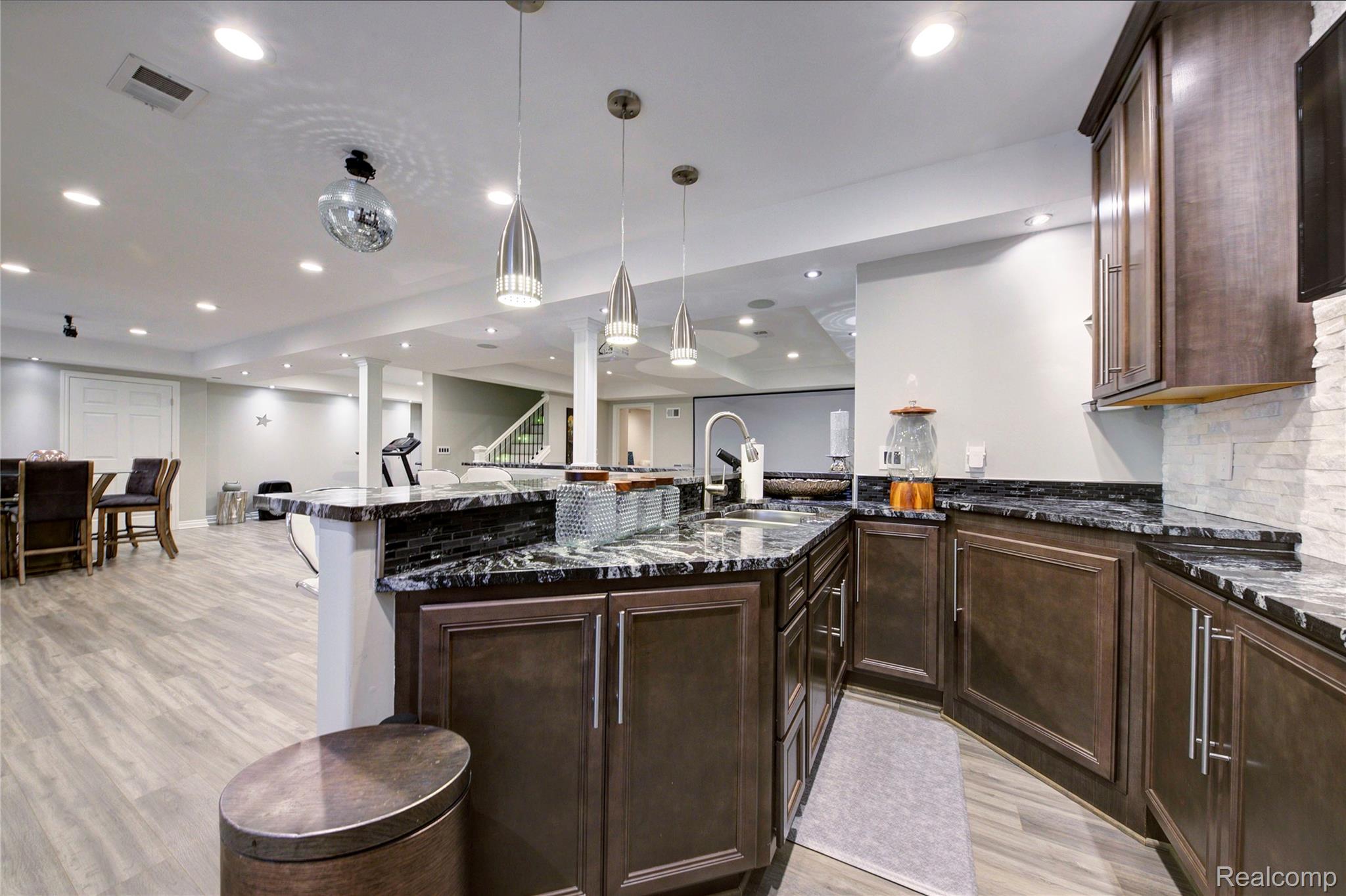 50411 Lansdowne Road Canton, MI 48188 - Photo 43 of 75 Kitchen featuring dark wood finish cabinetry, dark stone counters, and light wood-style floors