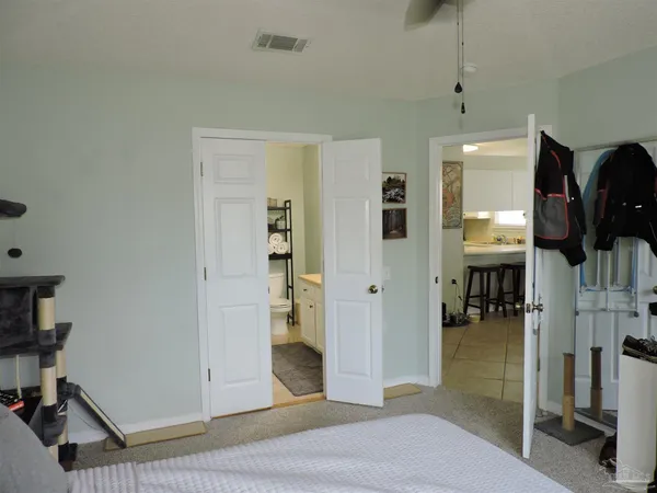 a view of a livingroom with wooden floor and a bathroom