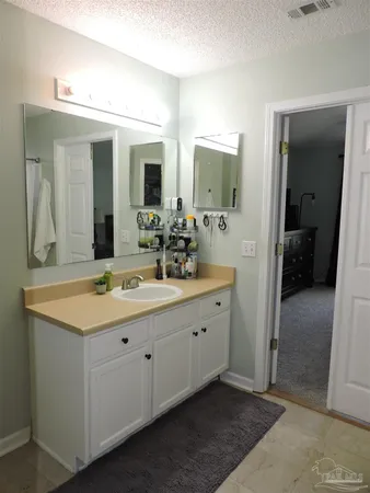 a spacious bathroom with a double vanity sink and mirror