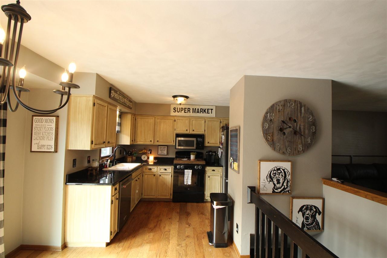 3684 Valerie Road Roscoe, IL 61073 - Photo 6 of 26 a kitchen with stainless steel appliances granite countertop a stove a refrigerator and a dining table with wooden floor