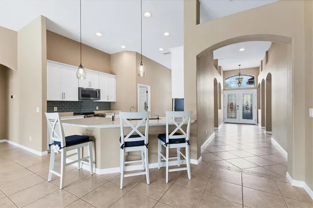 a kitchen with stainless steel appliances kitchen island granite countertop a sink a stove a microwave a dining table and chairs