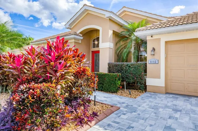 a front view of a house with a lots of flowers
