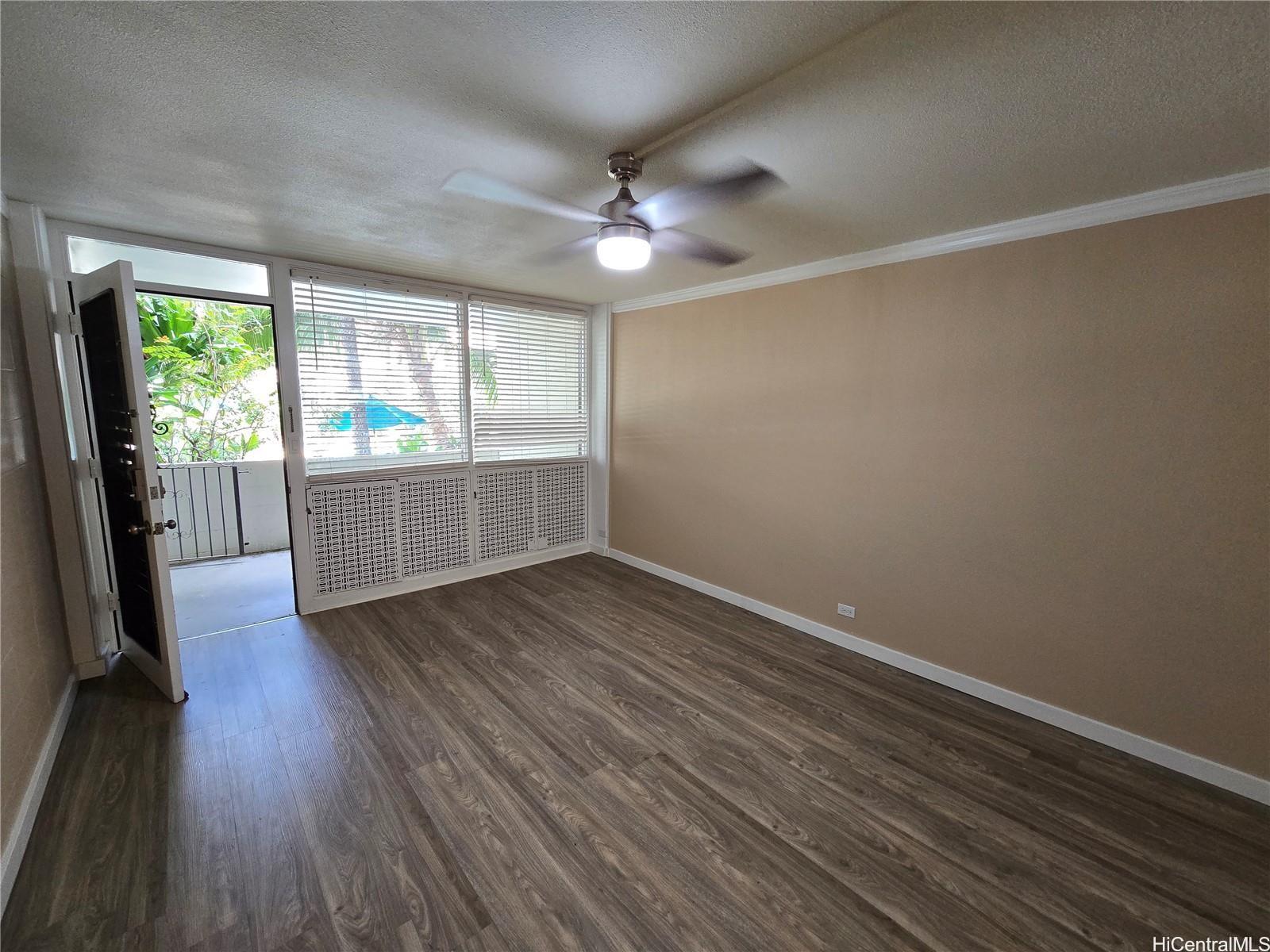 an empty room with wooden floor and windows
