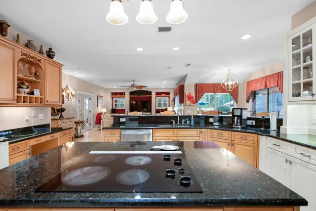 a very nice looking kitchen with granite countertop a stove and cabinets