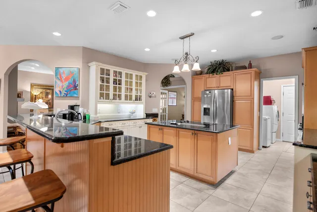 a living room with furniture a ceiling fan and a large window