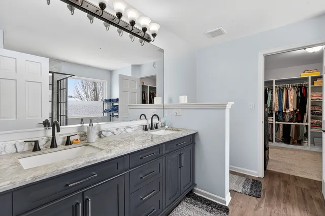 a bathroom with a granite countertop sink a mirror and shower
