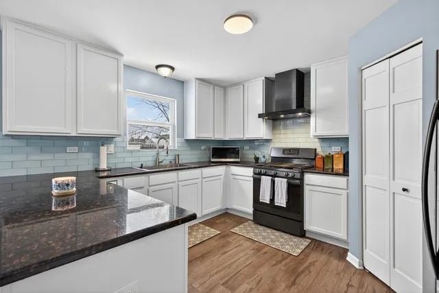 a kitchen with stainless steel appliances granite countertop a stove a sink and a refrigerator