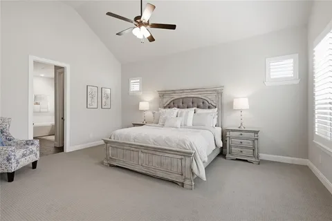 a bedroom with a bed chandelier and a window