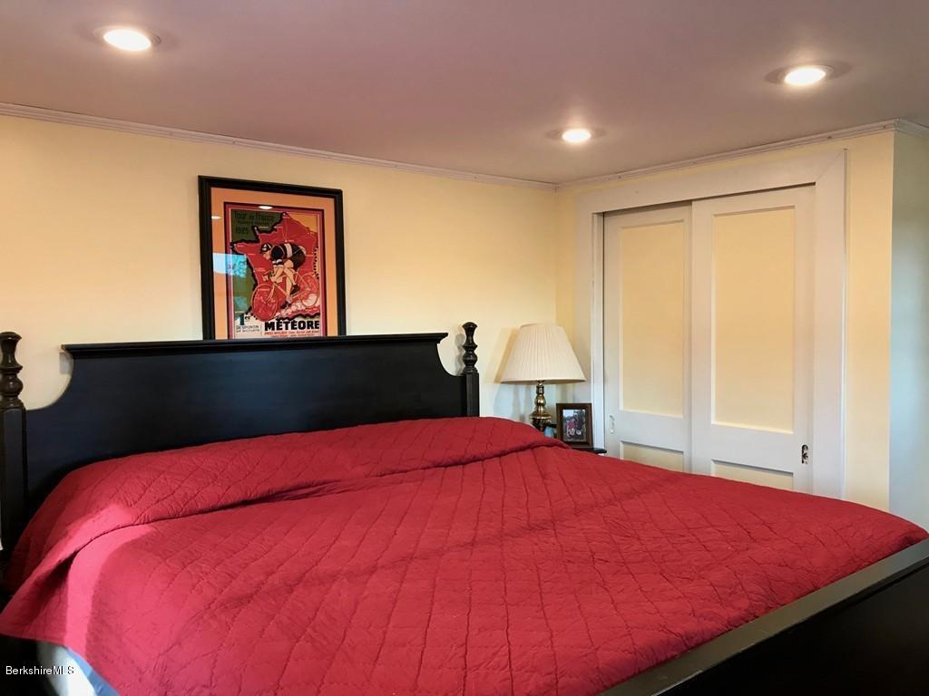 221 Number 9 Road Rowe, MA 01367 - Photo 14 of 27 a bed sitting in a bedroom next to a window