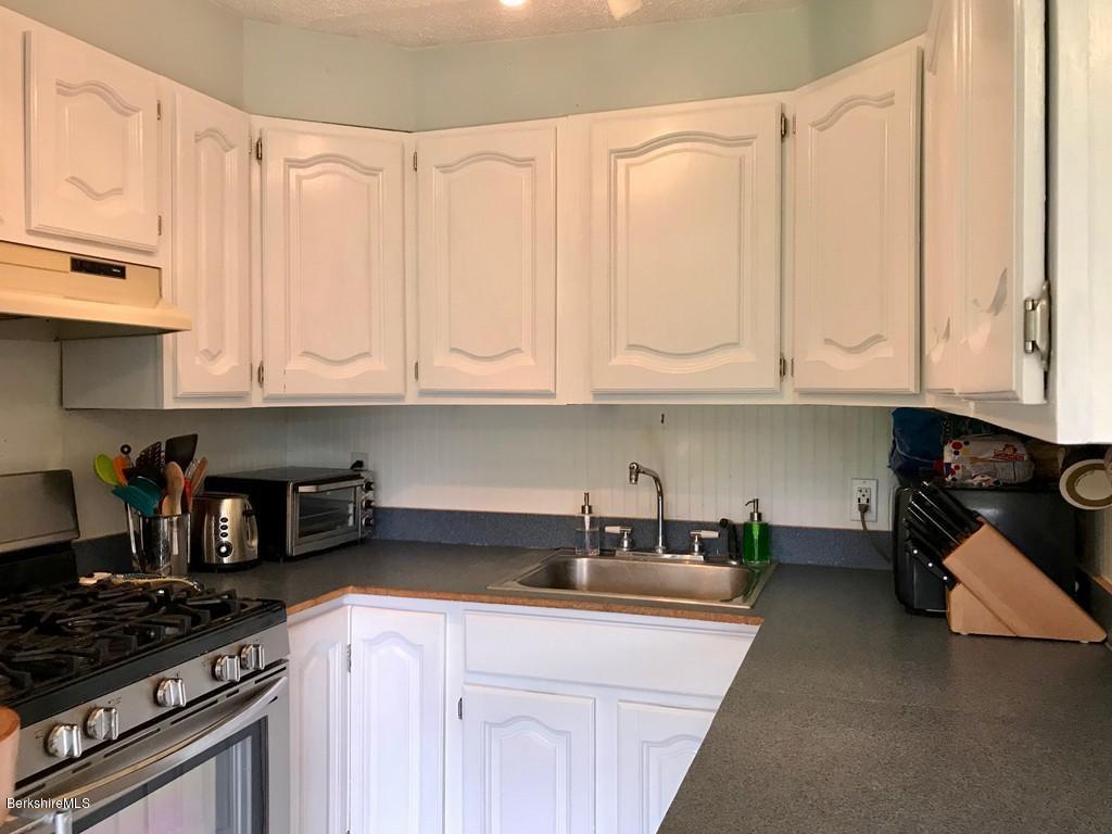 221 Number 9 Road Rowe, MA 01367 - Photo 8 of 27 a kitchen with stainless steel appliances granite countertop a sink stove and cabinets