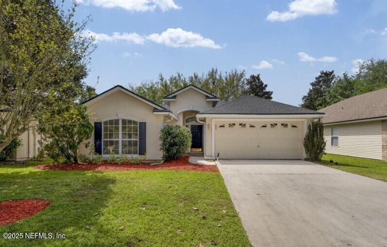 a view of a house with a yard and potted plants