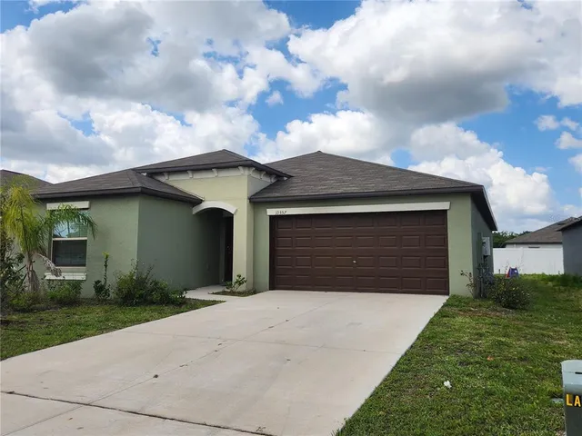 a front view of a house with a yard and garage