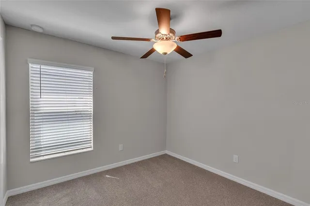 an empty room with chandelier fan